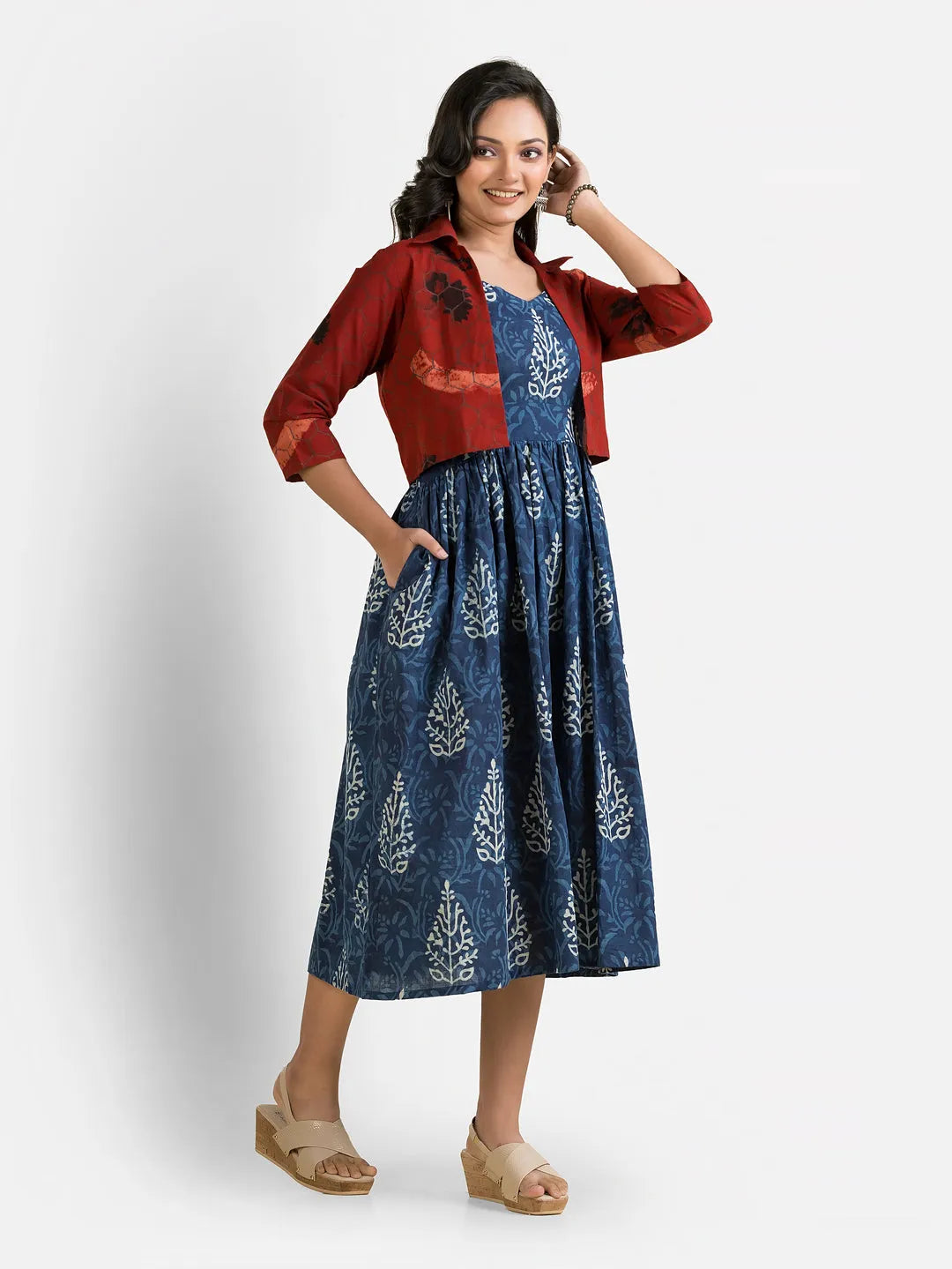 Women's blue gown with a maroon jacket, elegantly draped on a mannequin, showcasing its vibrant colors and stylish design.